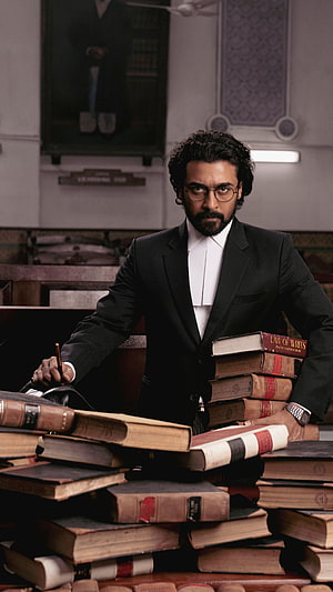 Aishwarya Rai Bachchan in a formal black suit with a stack of law books in a courtroom setting HD phone wallpaper