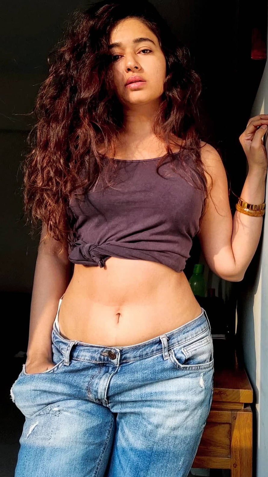 Poonam Bajwa in a knotted crop top and distressed denim jeans HD phone wallpaper