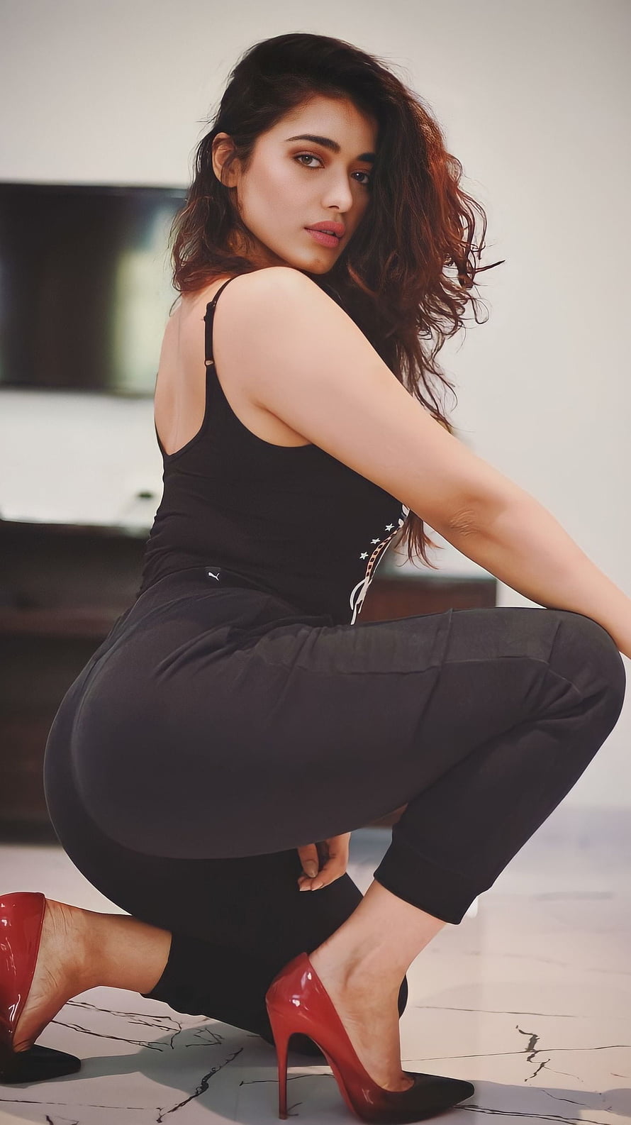 Pooja Hegde posing in black outfit and red heels HD phone wallpaper