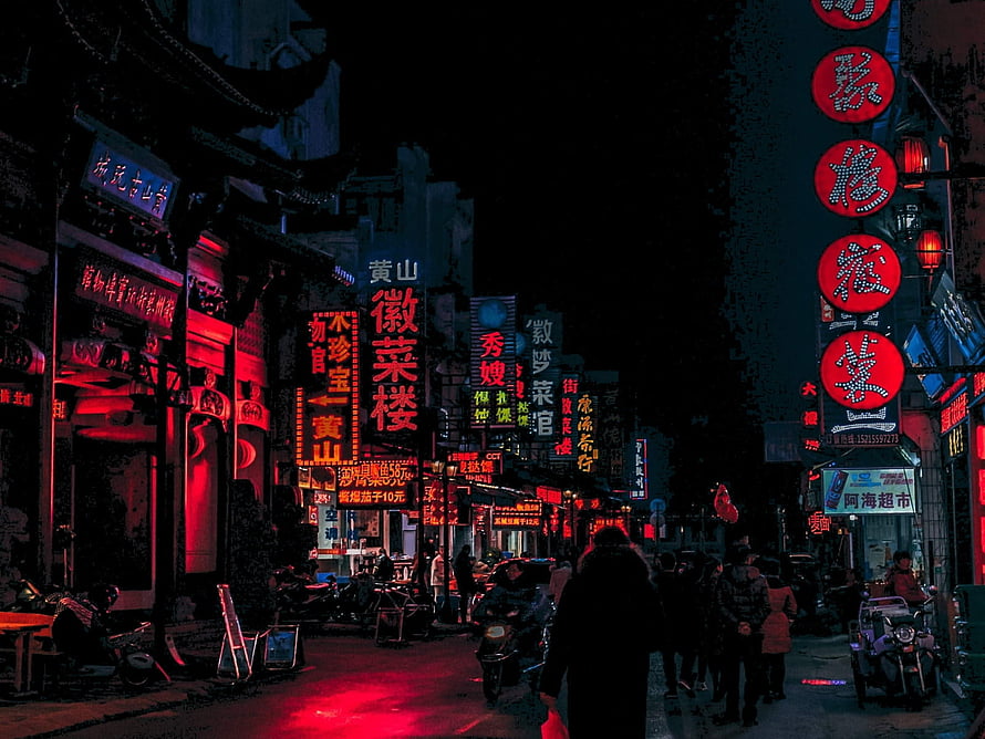 Neon-lit Chinese street at night with glowing red signs and pedestrians HD wallpaper