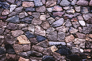 Rustic Dry Stone Wall Texture with Varied Earth Tones and Rough Natural Rock Surfaces HD wallpaper