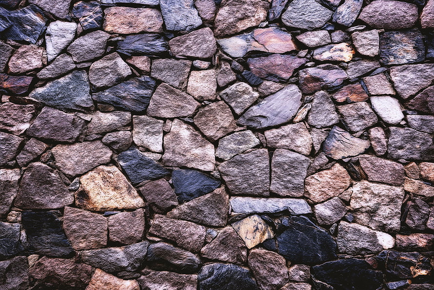 Rustic Dry Stone Wall Texture with Varied Earth Tones and Rough Natural Rock Surfaces HD wallpaper