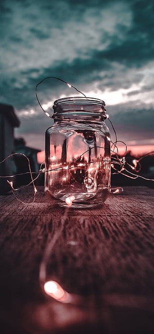 Glass Jar with Fairy Lights on Wooden Surface Against Dramatic Sky HD phone wallpaper