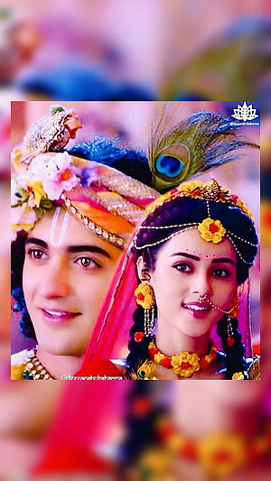 Krishna and Radha in traditional attire with peacock feather crown and floral jewelry HD phone wallpaper