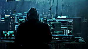 Anonymous Hacker in Hoodie Working on Multiple Monitors with Code and Data HD wallpaper