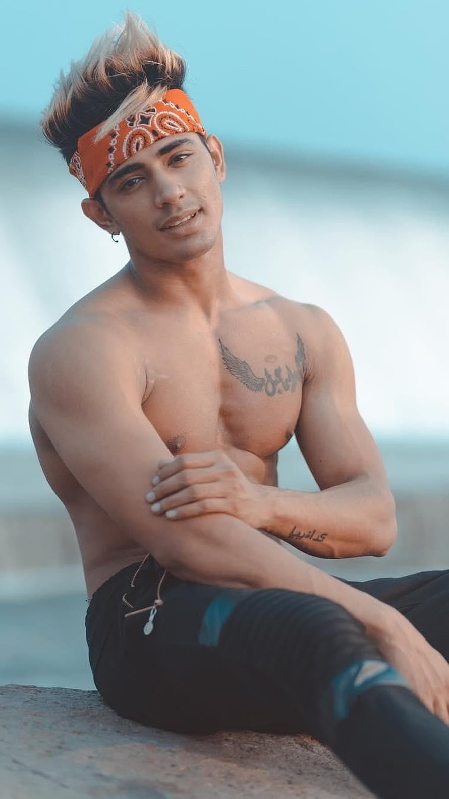 Danish Zehen Wearing Orange Bandana With Chest Tattoo Sitting By The Water HD phone wallpaper