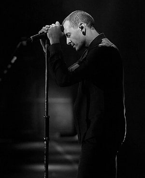 Black and white portrait of a male singer performing on stage with a microphone HD phone wallpaper