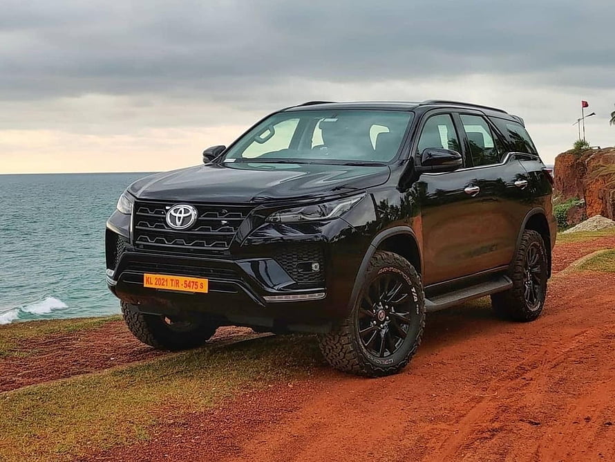 Black Toyota Fortuner SUV Parked on Coastal Cliff with Ocean View HD wallpaper