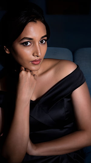 Srinidhi Shetty in an elegant black off-shoulder gown with dramatic studio lighting HD phone wallpaper