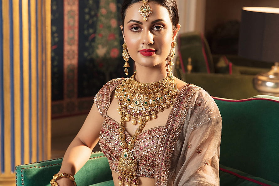 Elegant Indian Bride in Traditional Bridal Lehenga with Heavy Gold Jewelry and Maang Tikka HD wallpaper
