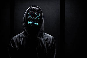 Anonymous Neon Mask Figure in Dark Hoodie with Glowing Cyan X Eyes and Stitched Mouth HD wallpaper