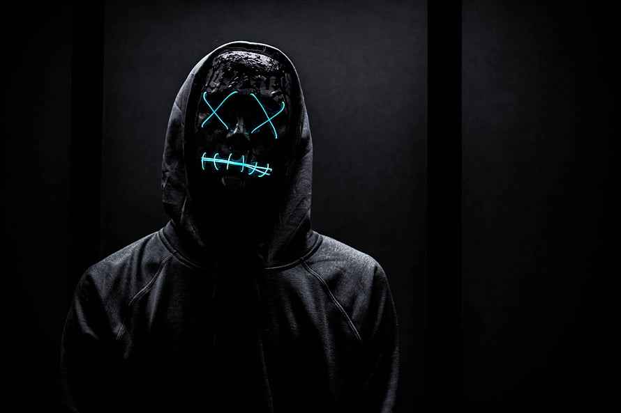 Anonymous Neon Mask Figure in Dark Hoodie with Glowing Cyan X Eyes and Stitched Mouth HD wallpaper