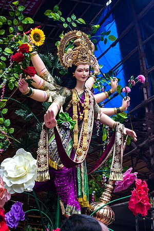 Vibrant Durga Puja Idol of Goddess Durga with Multiple Arms and Floral Decorations HD phone wallpaper