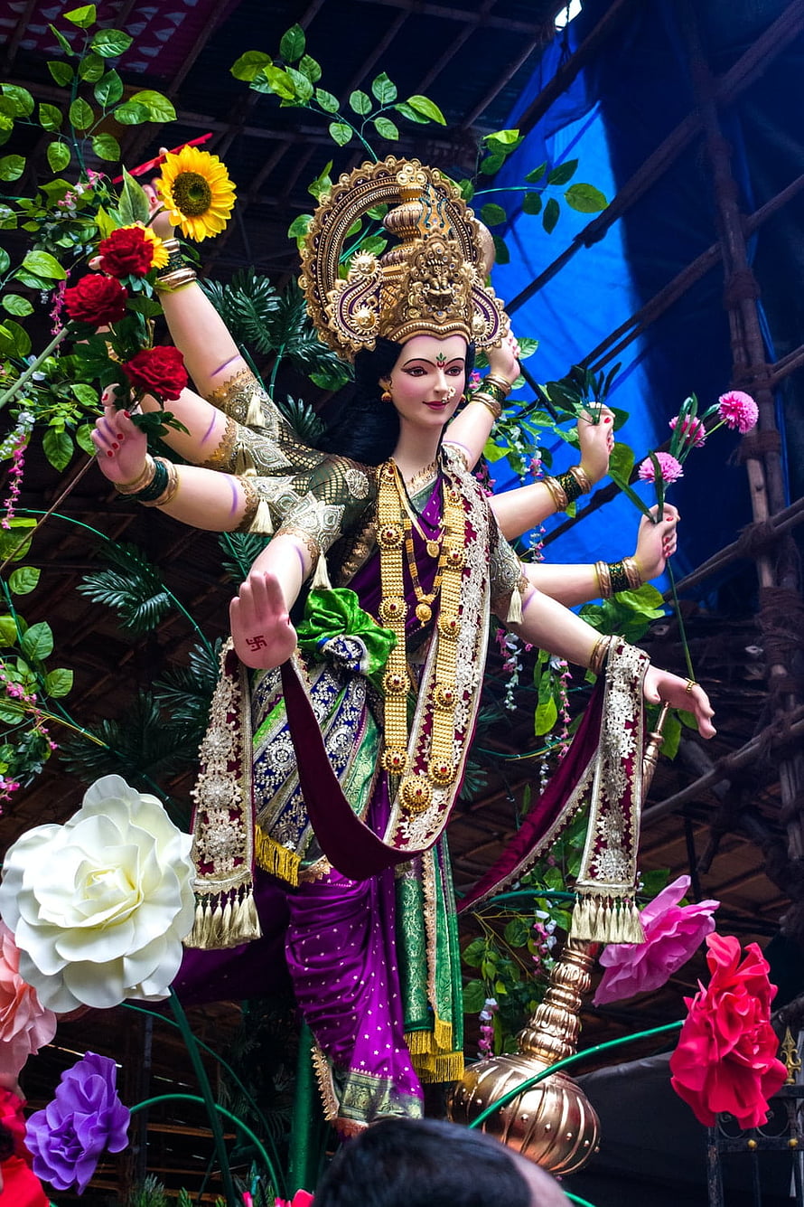 Vibrant Durga Puja Idol of Goddess Durga with Multiple Arms and Floral Decorations HD phone wallpaper