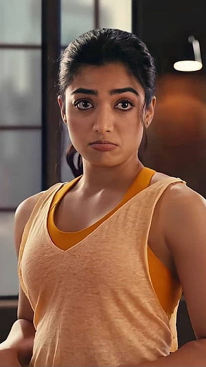 Rashmika Mandanna in a yellow tank top with a serious expression HD phone wallpaper