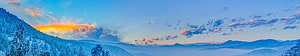 Snow-Covered Mountain Panorama at Sunset with Misty Valleys and Vibrant Sky HD wallpaper