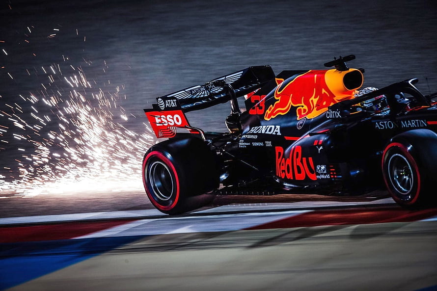 Red Bull Racing Formula 1 car kicking up sparks on the track at night HD wallpaper