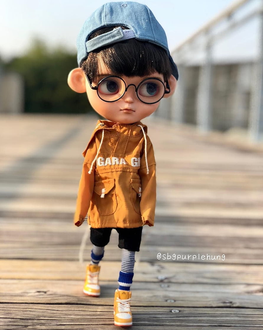 Dimoo Doll Wearing Orange Jacket and Blue Cap Walking on Wooden Deck HD phone wallpaper