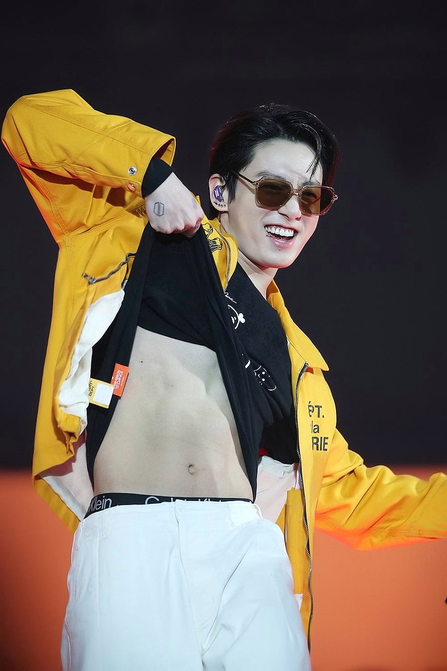 Jungkook from BTS performing on stage in a yellow jacket and sunglasses HD phone wallpaper