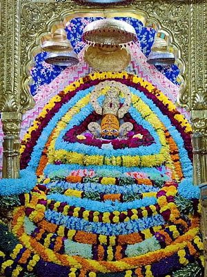 Vibrant Floral Decorations Adorning A Hindu Temple Deity Statue HD phone wallpaper