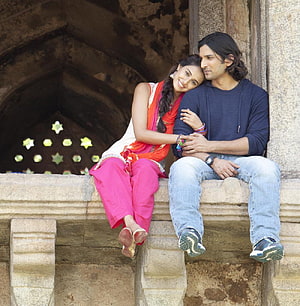Couple in Traditional Indian Attire Sitting on Stone Ledge at Historic Fort HD phone wallpaper