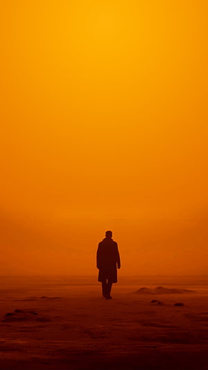 Silhouette of a Lone Walker in a Vibrant Orange Haze HD phone wallpaper