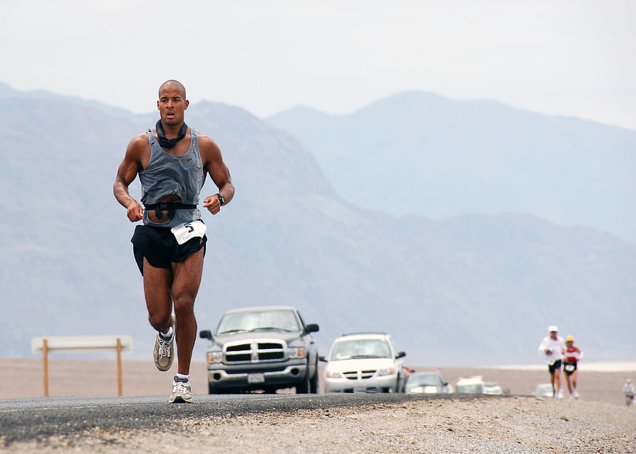Male Athlete Running on Desert Road with Mountains in Background HD wallpaper