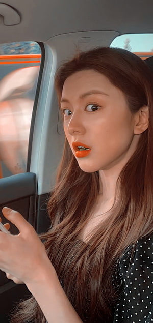 Go Yoon Jung in a car with long brown hair and bright orange lipstick HD phone wallpaper