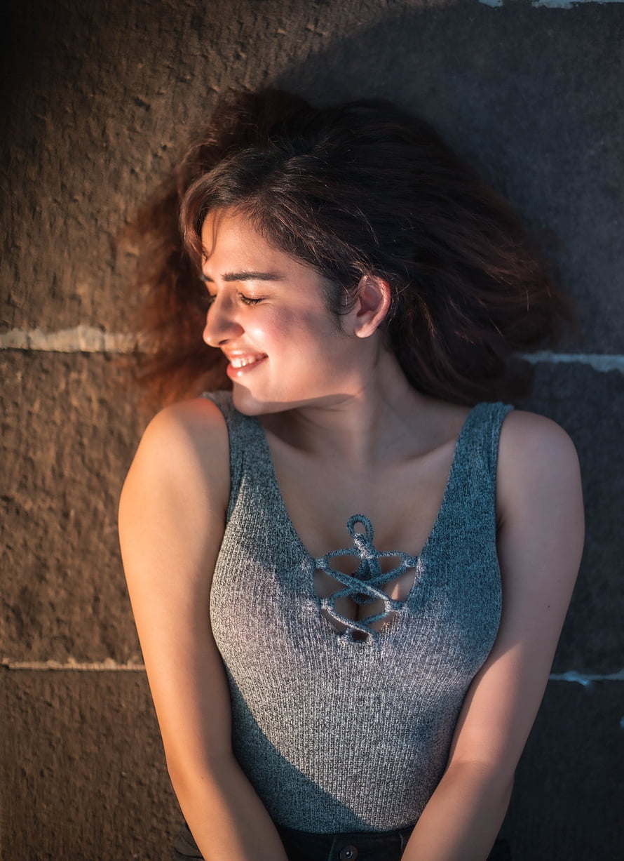 Shirley Setia in a Grey Knit Top with Warm Golden Hour Lighting Against a Textured Wall HD phone wallpaper
