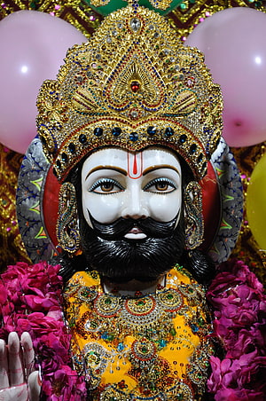 Ornate Hindu Deity Statue with Golden Crown and Floral Garlands HD phone wallpaper