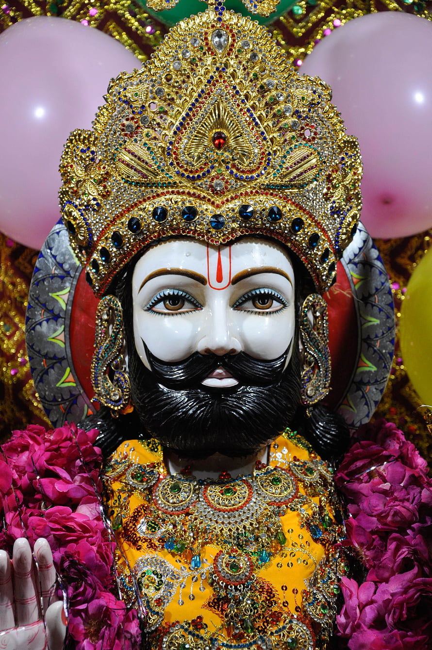 Ornate Hindu Deity Statue with Golden Crown and Floral Garlands HD phone wallpaper