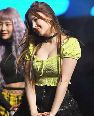 Nancy from Momoland performing on stage in a lime green smocked top and black skirt HD phone wallpaper