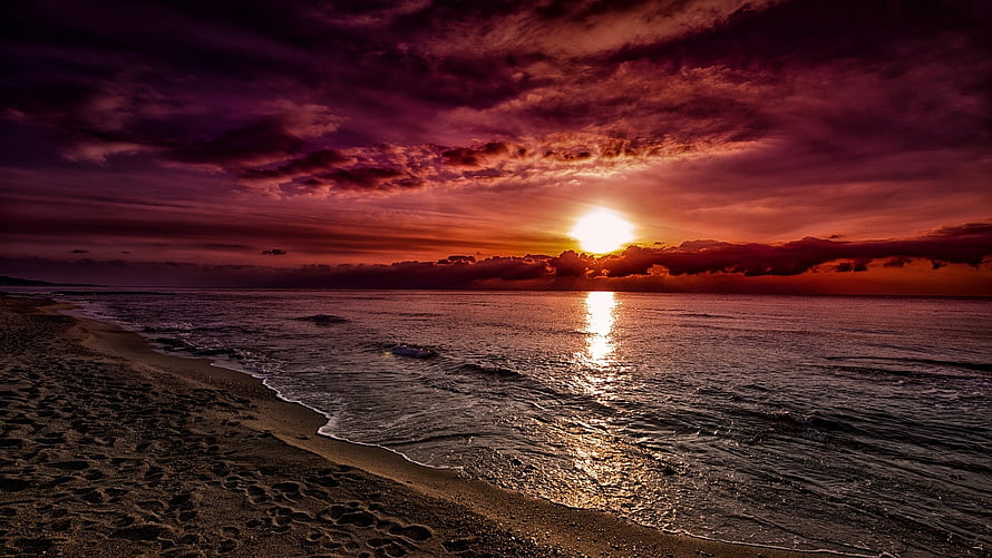 Dramatic Purple and Orange Sunset Over Ocean Beach with Cloudy Sky HD wallpaper