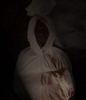 Pocong Ghost Wrapped in White Shroud with Dark Face in Shadowy Setting HD phone wallpaper