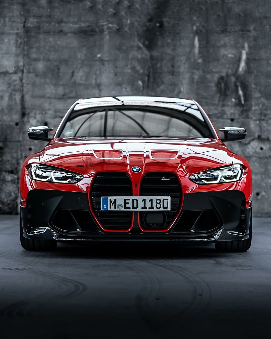 Red BMW M3 Competition Front View with M Performance Parts Against Concrete Wall HD phone wallpaper
