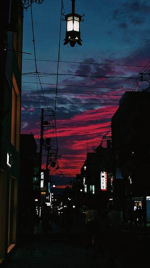 Vibrant Crimson Sunset Over a Silhouetted Japanese Street at Dusk HD phone wallpaper