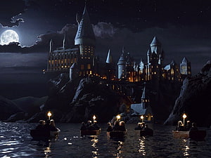 Hogwarts Castle at Night with Boats Crossing the Lake Under a Full Moon HD wallpaper