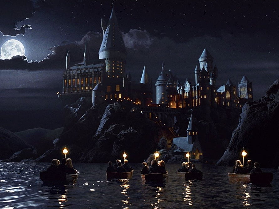 Hogwarts Castle at Night with Boats Crossing the Lake Under a Full Moon HD wallpaper