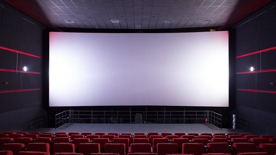 Empty Cinema Auditorium With Rows Of Red Seats Facing A Large White Projection Screen HD wallpaper