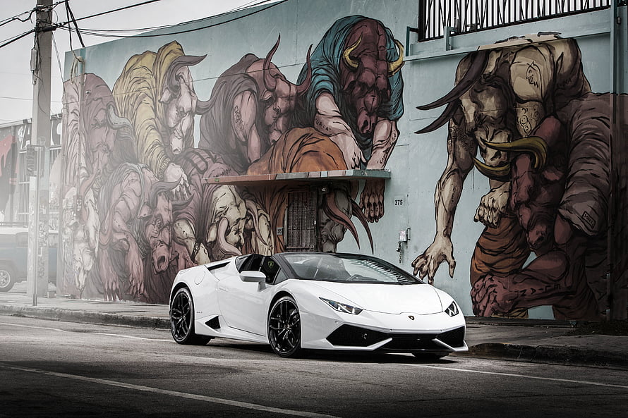 White Lamborghini Huracan Parked Before a Large Urban Street Art Mural HD wallpaper