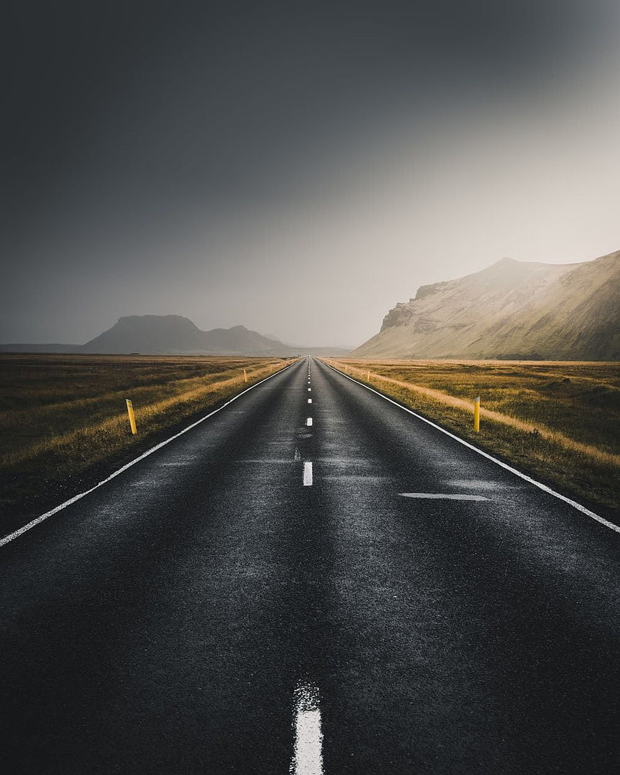 Moody Straight Highway Stretching Through Vast Open Landscape Under Dramatic Sky HD phone wallpaper