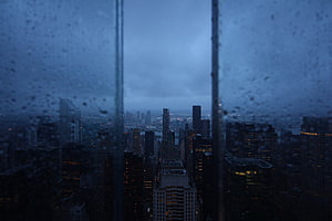 Moody Nighttime Cityscape Viewed Through a Rain-Streaked Window HD wallpaper