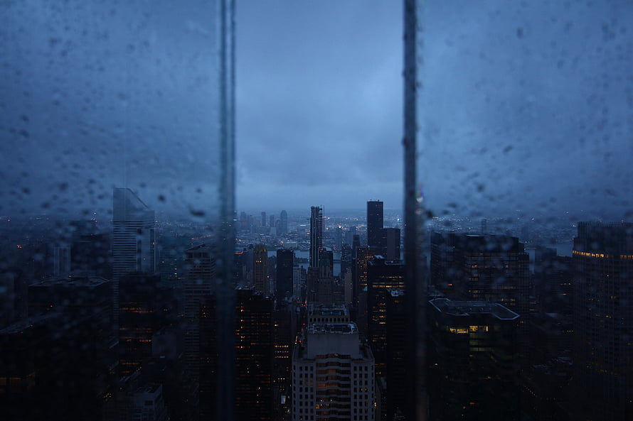 Moody Nighttime Cityscape Viewed Through a Rain-Streaked Window HD wallpaper