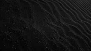 Dark Black Sand Texture with Fine Ripples and Grainy Surface Detail HD wallpaper