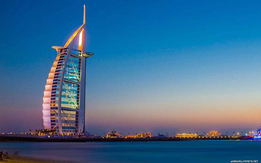 Burj Al Arab illuminated at dusk against a gradient twilight sky in Dubai HD wallpaper