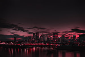 Dark Red City Skyline at Night with Dramatic Clouds and Water Reflections HD wallpaper