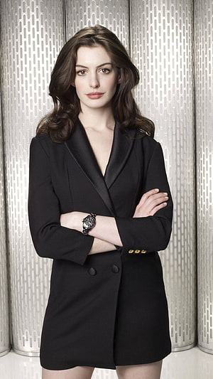 Anne Hathaway in a black blazer dress with arms crossed against a metallic background HD phone wallpaper