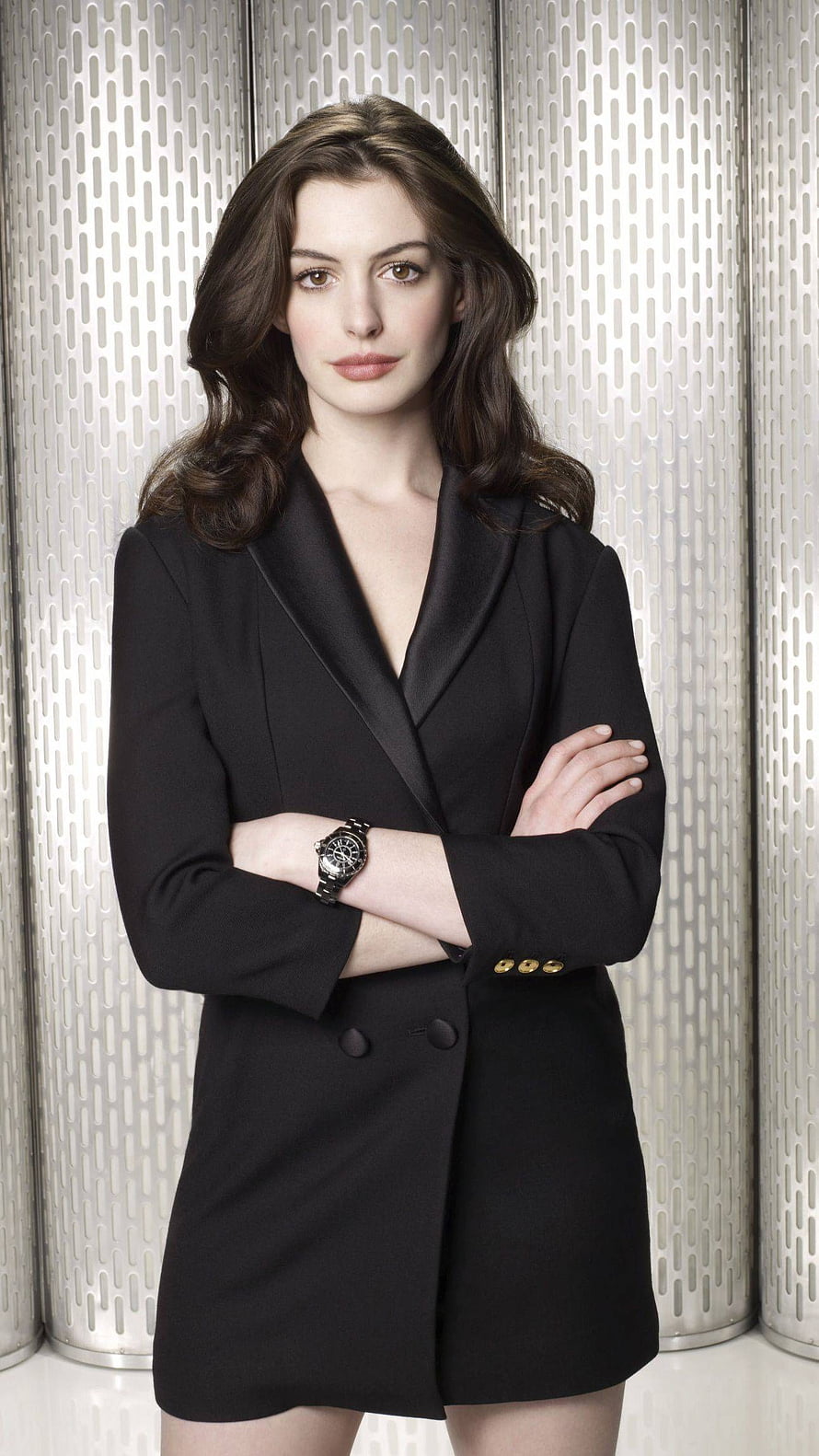 Anne Hathaway in a black blazer dress with arms crossed against a metallic background HD phone wallpaper