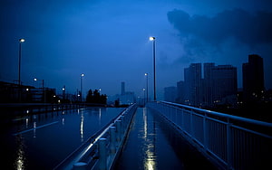 Moody Blue Night Cityscape on a Wet Bridge with Streetlights HD wallpaper