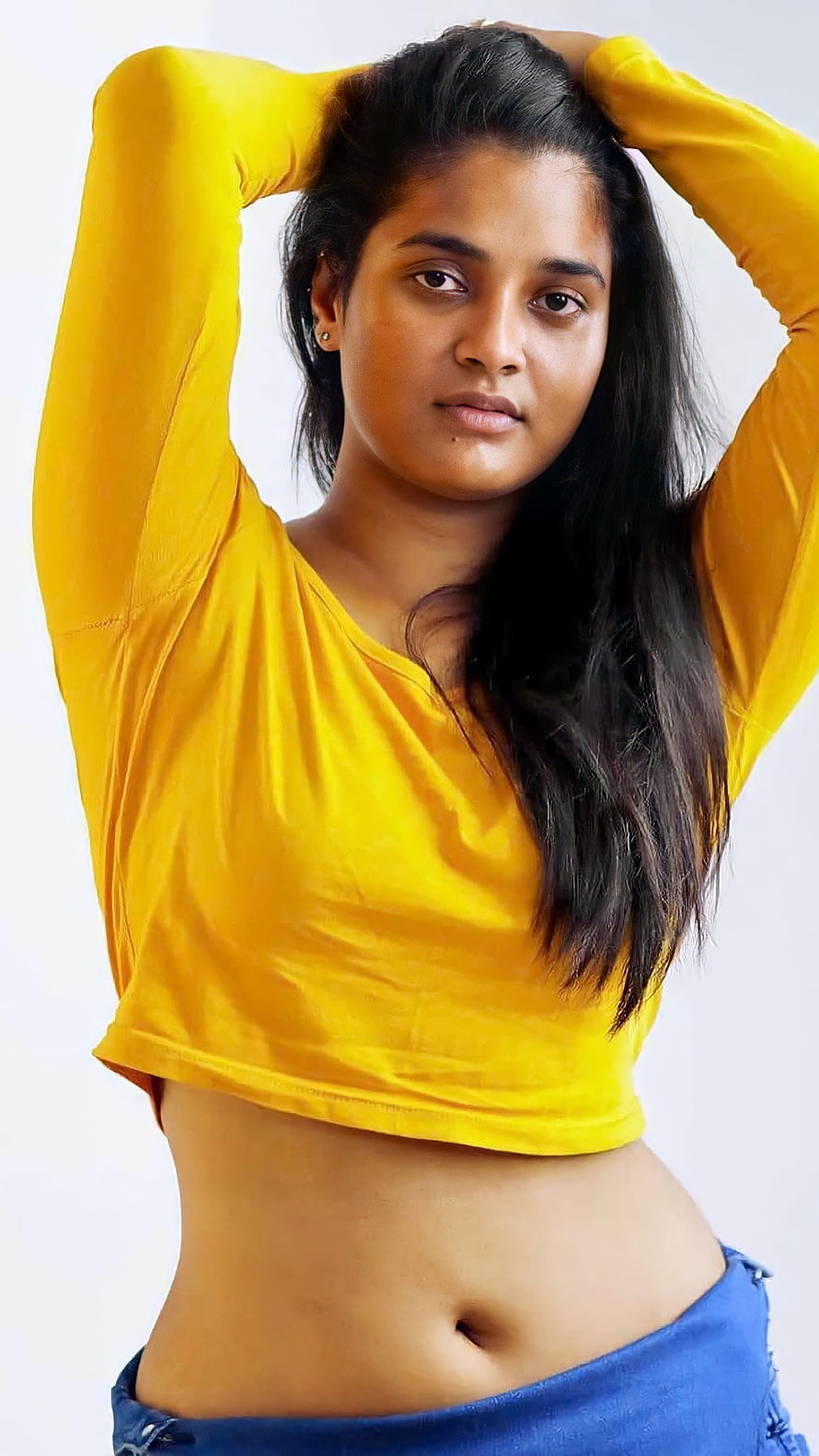 Soumya Shetty in a bright yellow crop top with hands raised behind her head HD phone wallpaper